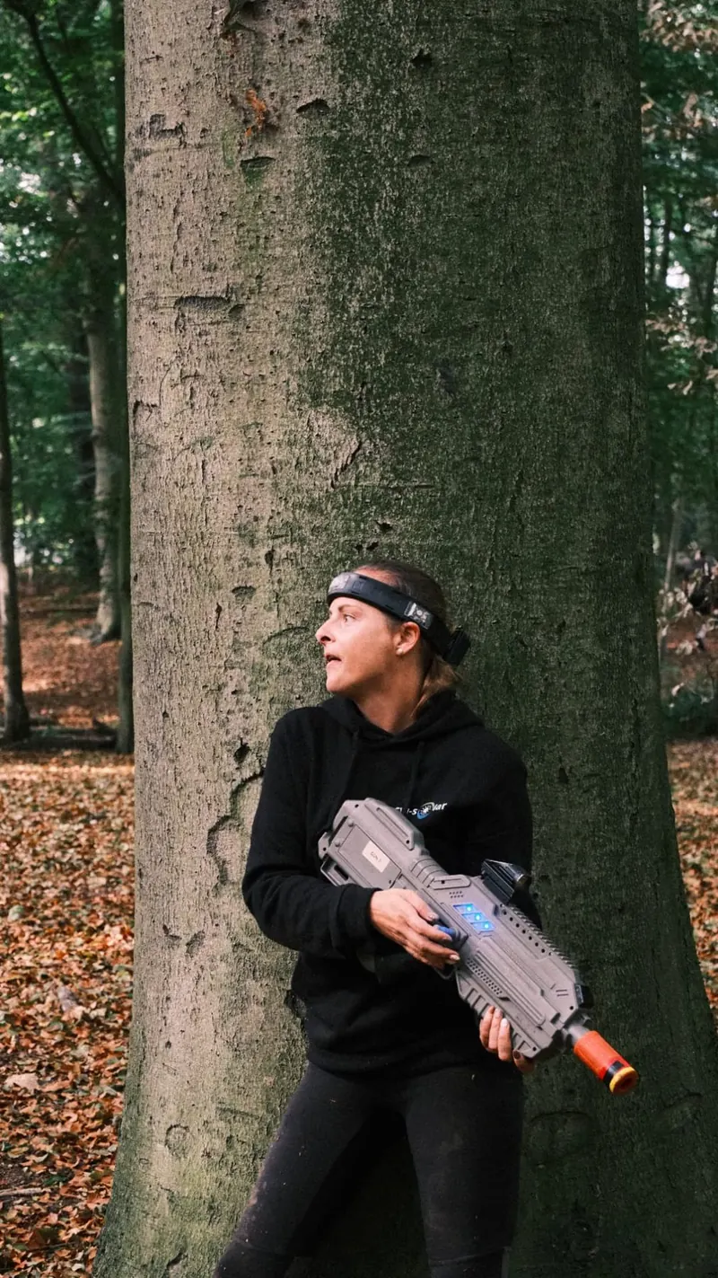 Deelnemer loopt door het bos tijdens een lasershoot van Bougez
