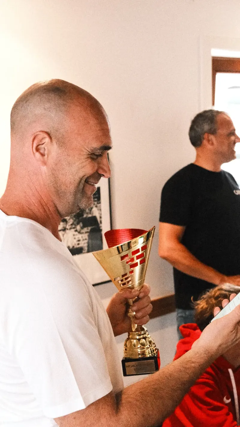 Winnaar bekijkt de beker na de Highland Games van Bougez