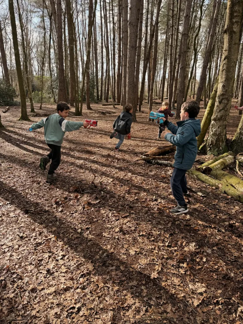 Kinderen rennen door het bos tijdens een lasershoot van Bougez