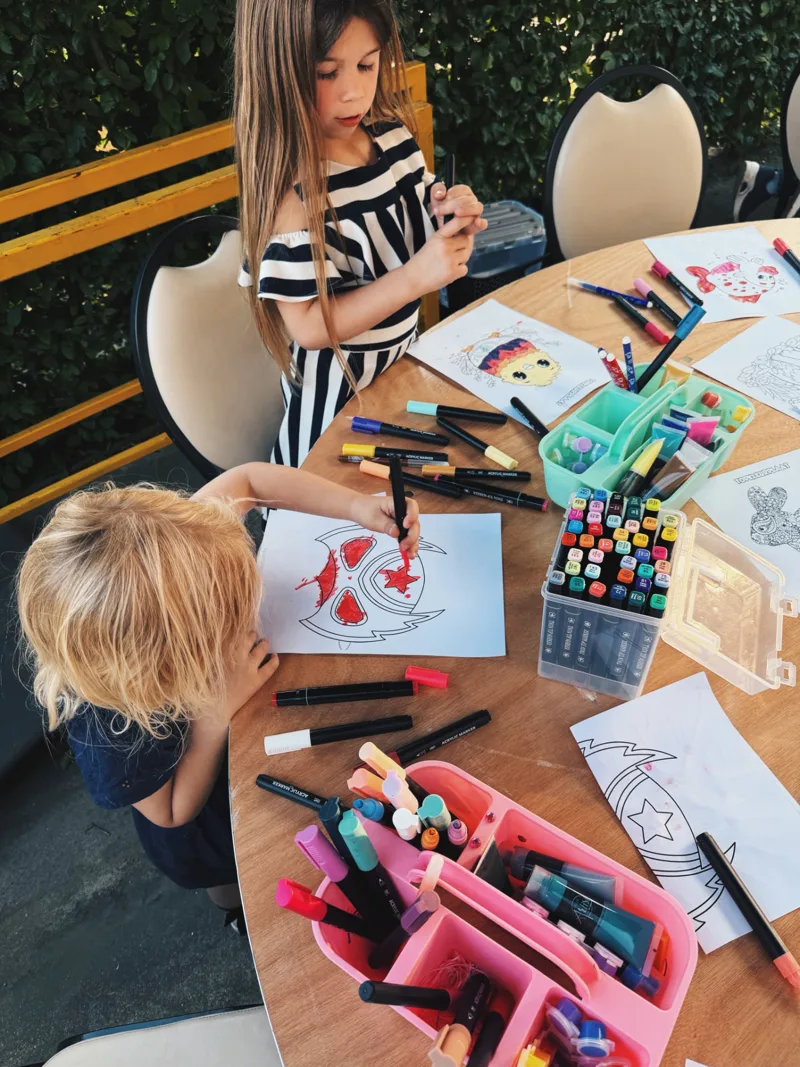 Twee kinderen kleuren met stiften aan een ronde tafel tijdens een kinderfeestje van Bougez