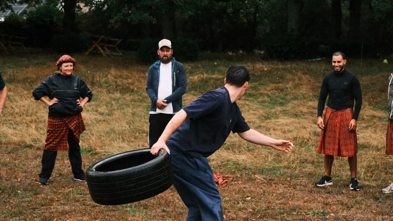 Deelnemer slingert een autoband weg tijdens de Highland Games van Bougez