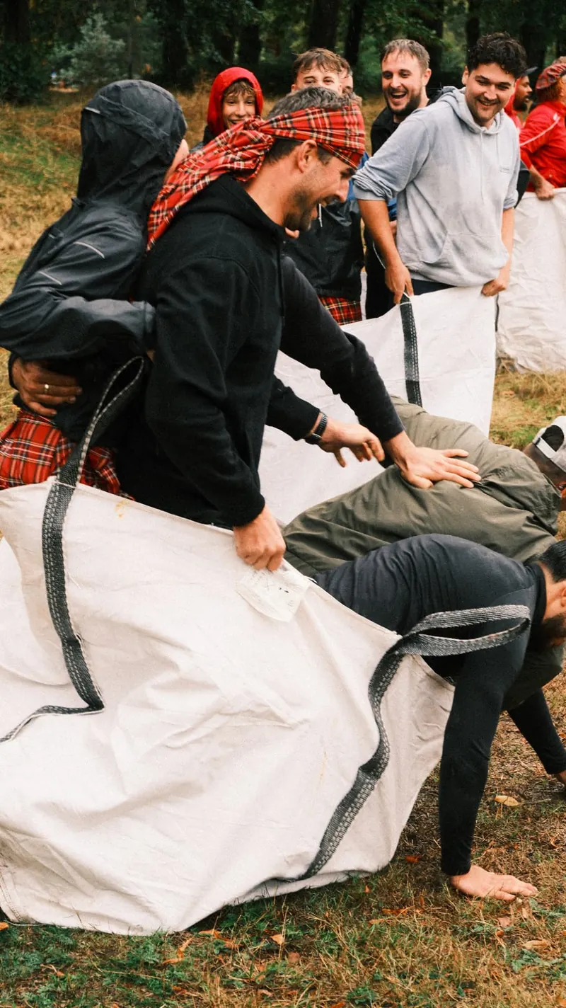Deelnemers helpen elkaar in de zak tijdens de zakloop op de Highland Games van Bougez