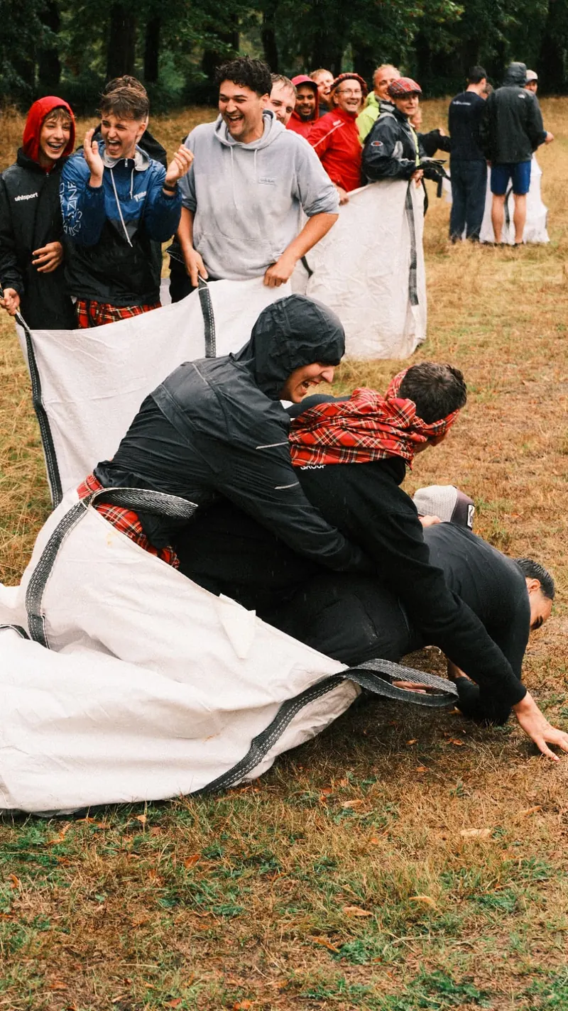 Teams vallen lachend om tijdens de zakloop op de Highland Games van Bougez